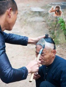 A chinese man having his head shaved